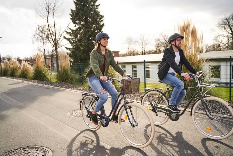 Kobieta i mężczyzna jadą rowerem miejskim po drodze