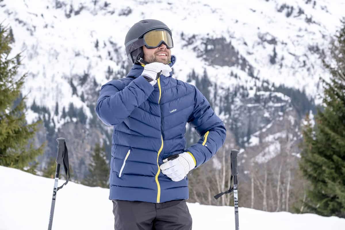 mężczyzna w niebieskiej kurtce narciarskiej
