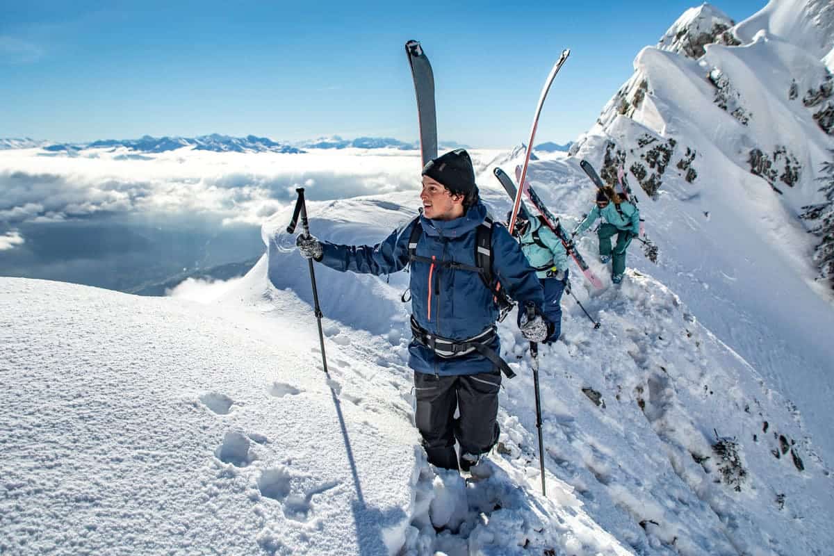 mężczyzna na stoku trzymający kijki narciarskie