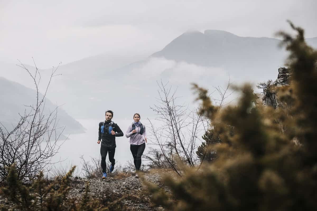 mężczyzna i kobieta biegający po górach
