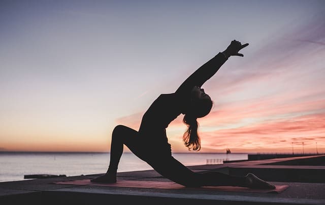 kobieta ćwicząca jogę przy zachodzie słońca