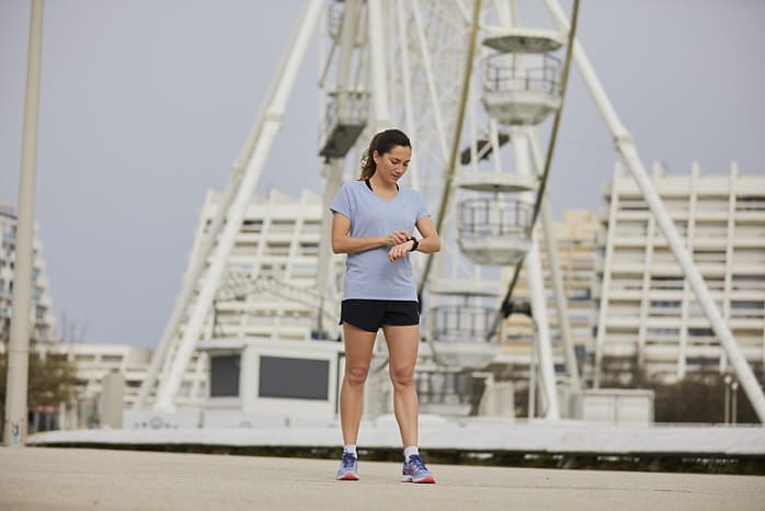 kobieta w stroju sportowym patrzy na zegarek do biegania 