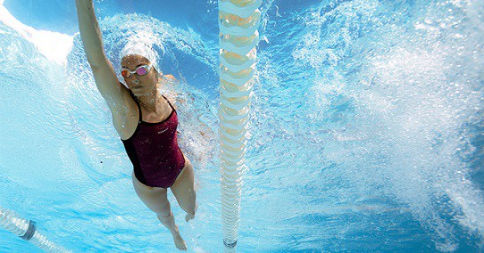 kobieta płynąca pod wodą w okularach pływackich