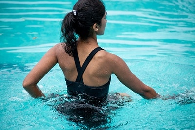 kobieta w stroju kąpielowym stojąca w wodzie