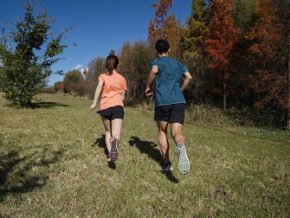 kobieta i mężczyzna biegnący po trawie w butach do biegania