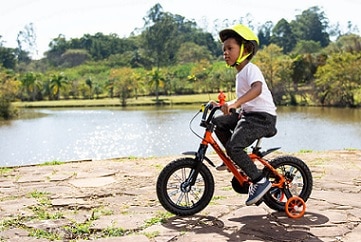 chłopiec jadący na rowerze w kasku 