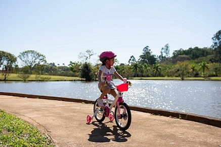 dziewczynka jadąca na rowerze w kasku