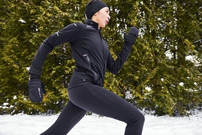 kobieta biegnąca zimą w rękawiczkach i stroju do biegania