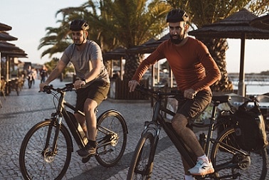 mężczyźni na rowerach elektrycznych w kaskach rowerowych
