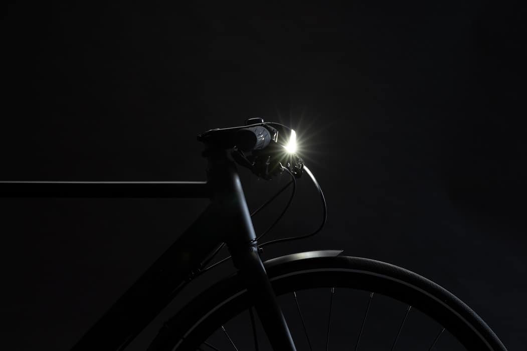 czarny rower z zapaloną lampą na kierownicy
