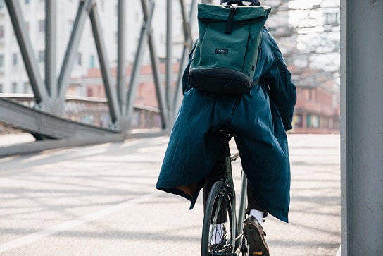 mężczyzna jadący na rowerze miejskim z plecakiem na plecach