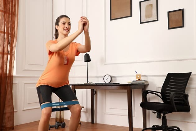 kobieta wykonująca ćwiczenia z gumą w odzieży fitness